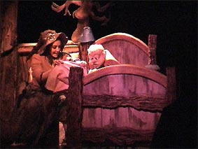 Manipulation d'une marionnette à double commmandes dans un décor en fausse perspective par le théâtre de mariionnettes du Théâtre en Chocolat.